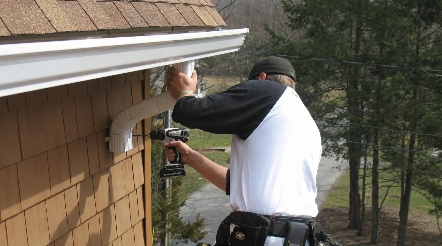 Professional contractor installing tan vinyl siding panels on a residential home exterior in Santa Ana, CA